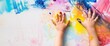 child hands covered in bright and vibrant paint, creating a colorful and artistic appearance Web banner with empty space 