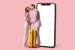 © Pixel-Shot - Beautiful young happy couple of tourists in headphones with suitcase kissing on pink background