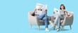 © Pixel-Shot - Young couple reading newspapers in armchairs on blue background with space for text