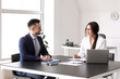 © Pixel-Shot - Human resources manager interviewing male applicant at table in office