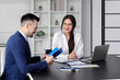 © Pixel-Shot - Human resources manager interviewing male applicant at table in office