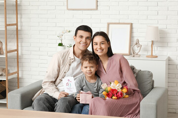 Wall Mural - Happy family greeting their mother with Mothers Day with bouquet of flowers and gift in living room