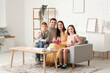© Pixel-Shot - Happy couple and children with bouquet of flowers and gift at Mothers Day in living room