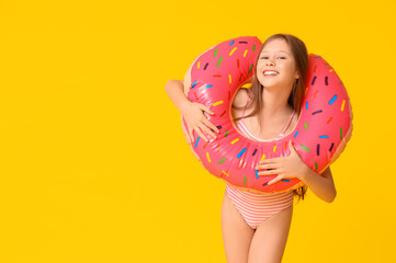 Sticker - Cute little happy girl in swimsuit with inflatable ring on yellow background