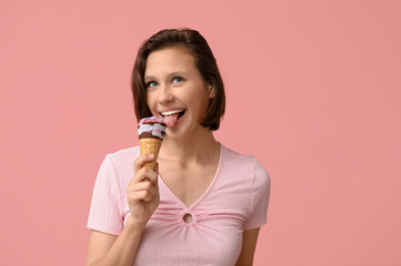 Canvas Print - Beautiful young woman eating sweet ice-cream in waffle cone on pink background