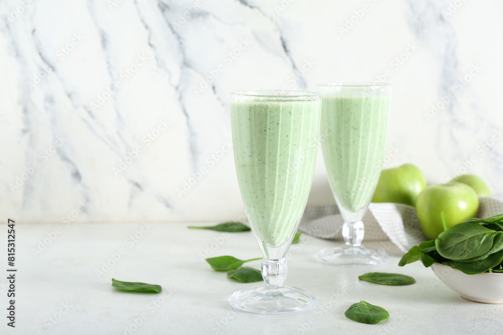 Glasses of fresh spinach smoothie with apple on white background