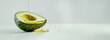 Avocado in oil splash flows  on light background. Healthy fats. Banner, copy space