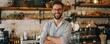 © amazingfotommm - Confident male entrepreneur stands in his well-designed coffee shop, arms crossed