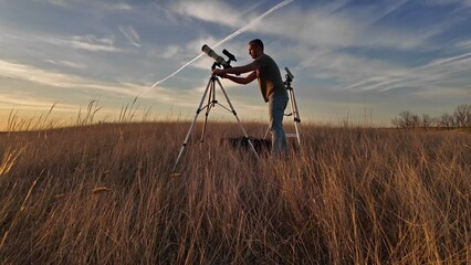 Wall Mural - amateur astronomer observing solar eclipse and sun with a telescope and special solar filter.