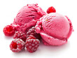 A close up of two pink ice cream scoops with raspberries on top