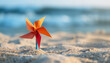 Paper pinwheel in a sand on the beach, summer concept, copy space