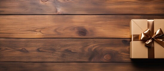 Poster - Wooden table with a top view showcasing a gift box beautifully decorated and accompanied by ample copy space
