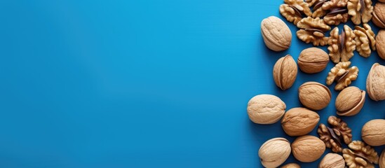Aufkleber - Top view of scattered halves of pulp and whole walnut on a blue background creating a visually pleasing copy space image
