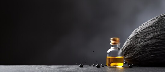 Poster - A dark grey background with a drop of essential oil providing ample copy space for images