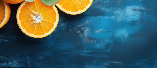 Aufkleber - A top down view of ripe juicy oranges The oranges have been cut in half and are displayed on a blue concrete background A wooden reamer is visible in the image. Creative banner. Copyspace image