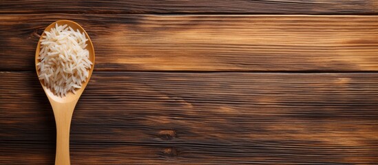 Poster - A copy space image of rice with a spoon placed on a wooden background