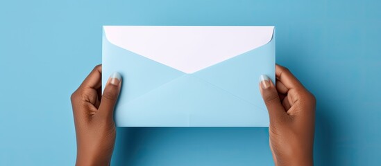 Poster - A blank card being inserted into an opened blue envelope by a hand with space for writing. Creative banner. Copyspace image
