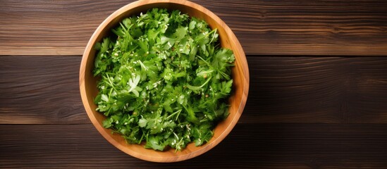 Aufkleber - A top down view of a wooden background featuring a bowl of fresh rucola salad with available copy space