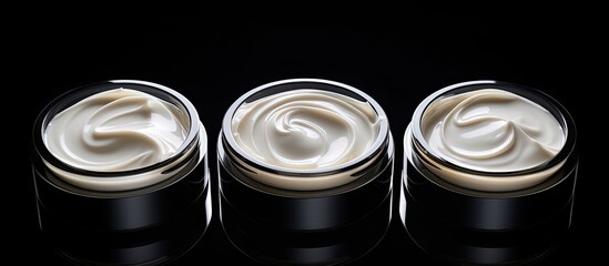 Poster - A top view of three isolated face cream jars on a black background with copy space for an image
