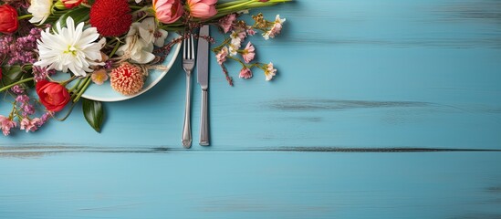 Aufkleber - Top view of a festive table arrangement on a blue wooden surface showcasing cutlery flowers and ribbons Copy space available