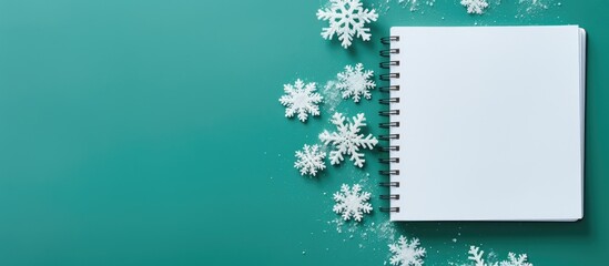 Leinwandbilder - The image depicts an open notebook alongside delicate snowflakes set against a vibrant green background This top down view offers ample space for personalization or additional elements