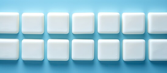 Leinwandbilder - A top down view of soap bars arranged neatly on a blue background with plenty of copy space in the frame