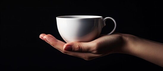 Poster - A cup is being held by a female hand with no other objects around captured in a copy space image