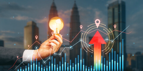 Poster - Close up of businessman hand holding lamp with growing forex chart with arrow on blurry city background. Financial growth and stock concept. Double exposure.