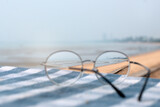 Fototapeta  - Sharp images look good when viewed with glasses, sea view through eyeglasses, selective focus and blurry background, vision concept