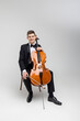 Passionate cello player sitting on chair performing concert
