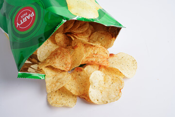 Bangkok, Thailand - May 15, 2022 Potato chips in open bag, delicious BBQ seasoning spicy for crips, thin slice deep fried snack fast food in open bag.