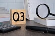 © izzuan - Close up image of wooden cubes with alphabet Q3 on office desk. Third quarter concept.