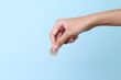 © Gatot - Woman hand holding a coin isolated on blue background