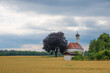 chapel beside grain field, grey clouds