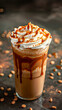 Iced coffee with whipped cream and caramel on a dark background.