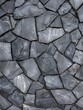 Close-up view of a textured gray slate wall with varied stone sizes and subtle color variations..