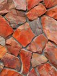 Vivid rustic red stone cladding with varied hues and textures for a rich visual appearance.