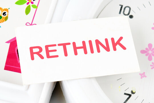 Rethink Business Concept text text on the business card on the background of the clock