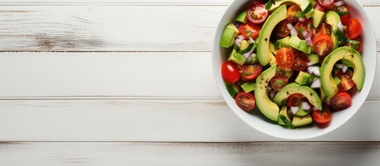 Poster - Fresh Avocado Tomato Salad in a bowl on a white wooden background top view Flat lay overhead from above Copy space