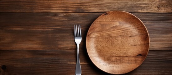 Wall Mural - Empty plate with silver fork and knife on wooden background. copy space available