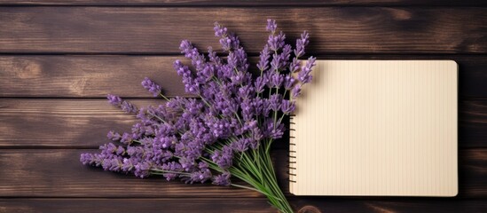 Poster - Bouquet of beautiful preserved lavender flowers and notebook on wooden table top view Space for text. copy space available