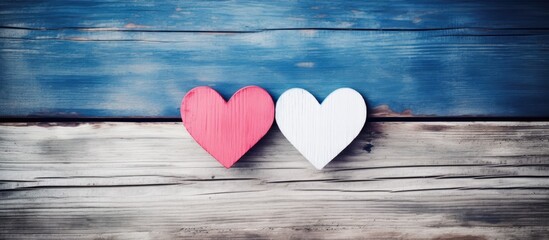 Poster - Top view of handmade pink and red heart on blue and white color wooden background with pastel vintage style Broken hearted Love Wedding and Valentines day concept. copy space available