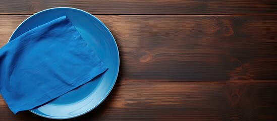Poster - Empty blue plate and napkin on a wooden background with copy space