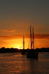 Wall Mural - Vertical of boats sailing at golden sunset