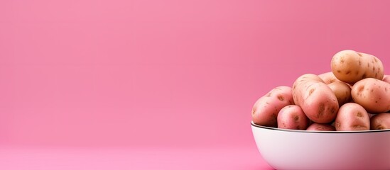 Poster - Bowl with raw baby potatoes on pink background. copy space available