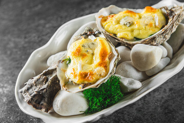 Wall Mural - Baked oysters on a bed of stones with garnish, an elegant seafood dish.