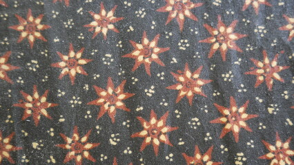Poster - Close up of a colorful batik cloth pattern on black background.. Thai silk fabric pattern, Thai silk fabric pattern background.