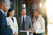 © peopleimages.com - Outdoor, men and women with document, project and reading paperwork for planning of deal and teamwork. Collaboration, employees and executive in discussion for meeting, banker and folder of corporate