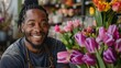 © HSGraphics - Smiling African American Florist Proudly Displays Purple Tulip At Her Flower Shop