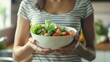 © antkevyv - Mindful eating practice, woman holding bowl of vegetables